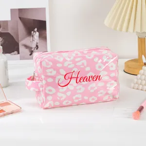 Pink leopard print PVC cosmetic bag with zipper and handle, perfect for travel and daily use.