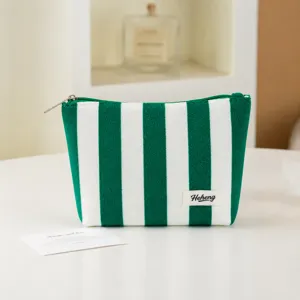 Green and white striped makeup pouch detail, soft fabric zipper cosmetic bag for daily use.