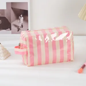 Detailed view of the stylish pink and white striped PVC cosmetic bag with zipper and handle.
