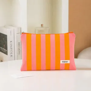 Portable waterproof makeup pouch with pink orange vertical stripes, ideal for travel storage.