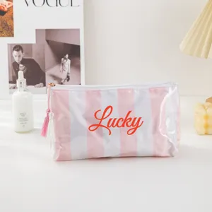 Clear PVC striped cosmetic bag with cute tassel zipper, portable travel makeup pouch.