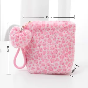 Detail view of the pink fluffy leopard cosmetic bag, showing dimensions, heart plush charm.
