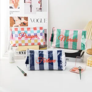 Portable PVC striped cosmetic bag stylish travel storage pouch with tassel zipper design.