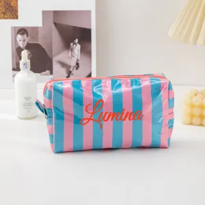 Detailed view of the pink and blue striped PVC cosmetic pouch with secure zipper closure.