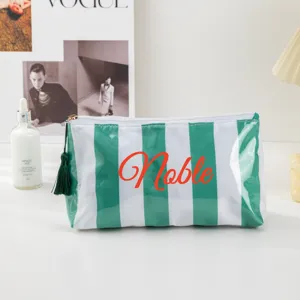 Green and white striped cosmetic bag with tassel zipper, stylish PVC travel makeup pouch.