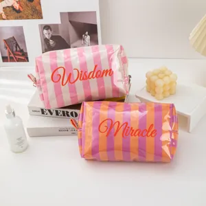 Waterproof PVC striped cosmetic bag with zipper, stylish travel makeup storage pouch.