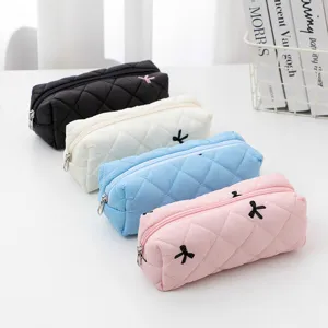 Detailed view of quilted pencil cases in multiple colors with cute bow embroidery and zip closure.