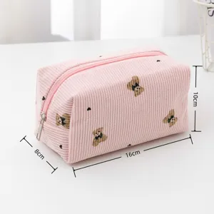Pink corduroy cosmetic bag detail showing cute bear embroidery and zipper closure design.