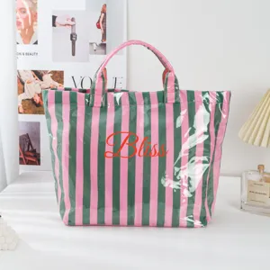 Detailansicht der rosa-grünen PVC-Tasche mit Bliss-Aufdruck und glänzender Oberflächenstruktur.