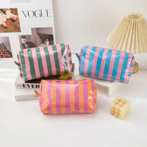 Detail shot of colorful PVC striped cosmetic bags, waterproof zipper toiletry storage pouches.