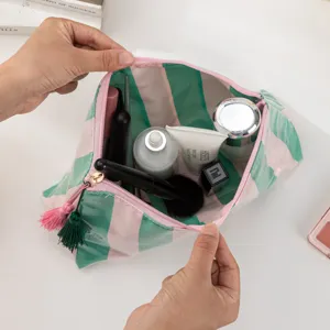 Clear PVC cosmetic bag with green and pink stripes, portable travel makeup storage pouch.