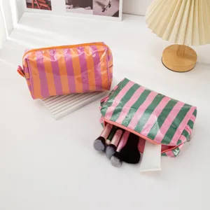 Colorful striped PVC cosmetic bag with zipper for travel and makeup storage organization.