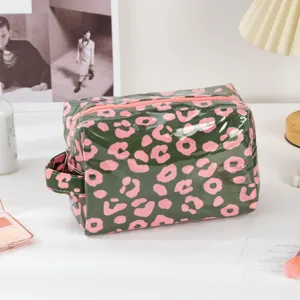 Waterproof PVC makeup bag with pink leopard print, zipper and side handle for travel use.