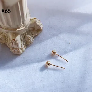 Minimalistische goldene Kugel-Ohrstecker, kleine runde Metallohrringe, eleganter Schmuck.