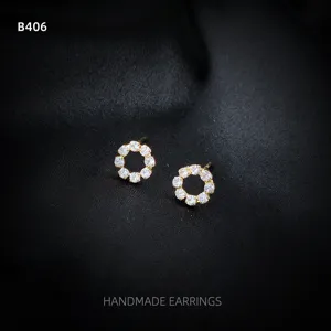Nahaufnahme von exquisiten 14k vergoldeten runden Zirkonia Ohrsteckern im handgefertigten Stil.