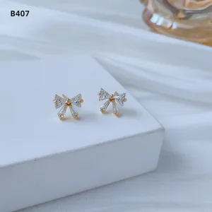 Nahaufnahme von Mini Kristall Schleife Ohrringen, elegantes vergoldetes Schmuckdetail.