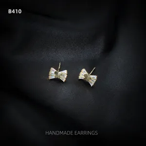 Detailansicht minimalistischer 14K vergoldeter Zirkon Schleifen Ohrstecker für Damen.