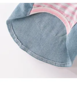 Detailed view of cute pet dog denim vest dress with pink striped fabric and fine stitching.