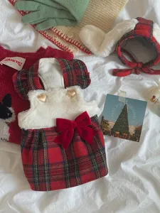 Detailaufnahme des weihnachtlichen karierten Haustierkleides mit Plüsch und Schleife.