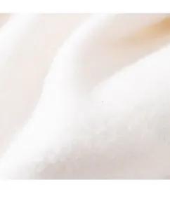 Nahaufnahme der weissen flauschigen Fleecestoff Textur fuer kuschelwarme Haustierkleidung.
