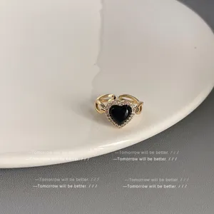 Mikrogefasster Zirkonia schwarzer Herzring, goldfarbener offener verstellbarer Ring Detail.