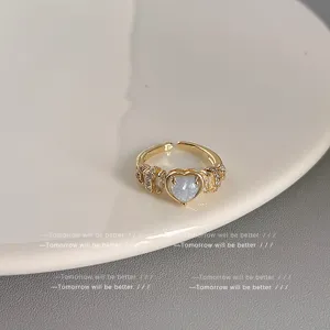Detaillierte Nahansicht eines filigranen vergoldeten Zirkonia-Herzrings mit funkelnden Steinen.