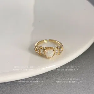 Nahaufnahme eines filigranen goldenen offenen Rings mit funkelndem herzförmigen Stein.