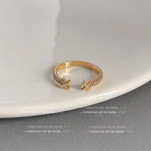 Detailaufnahme eines minimalistischen goldenen offenen Rings mit strukturierter Band und