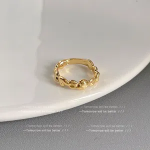 Eleganter goldener unregelmässiger wellenförmiger Metallring für Damen im modernen Stil.
