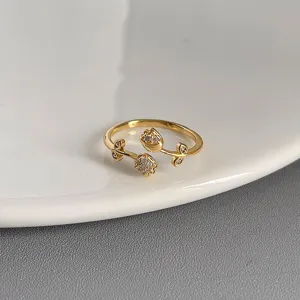 Nahaufnahme eines eleganten goldenen Blumen-Offenrings mit funkelnden Zirkoniasteinen.