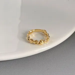 Goldener unregelmässiger Ring Detailansicht mit fliessendem Design und polierter Metallstruktur.