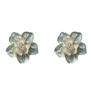 Elegant blue enamel flower stud earrings with sparkling rhinestones and gold-toned edges.