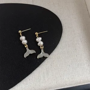 Nahaufnahme von Süßwasserperle und Walflosse Ohrringen mit eleganter Goldveredelung.