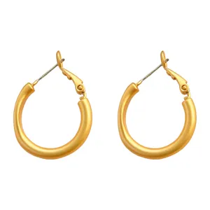 Nahaufnahme von matten goldenen Creolen mit filigranem minimalistischen Metallverschluss.