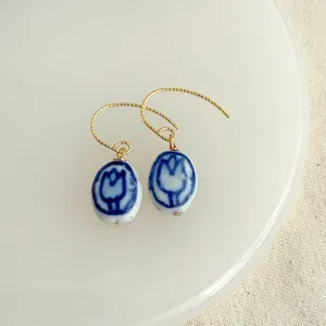 Detailansicht blaue weiße Porzellan Tulpenmuster Ohrringe, handgefertigter eleganter Ohrschmuck.