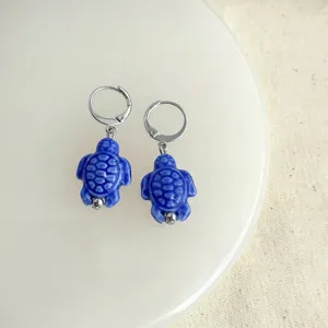 Handgefertigte blaue Schildkröten Ohrringe mit silbernen Klappbrisuren, elegante Keramik-Ohrringe.