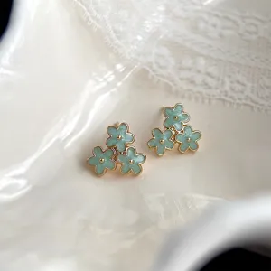 Nahaufnahme Detailansicht von mintgrünen Blumen Ohrringen mit filigranem Goldrand Design.