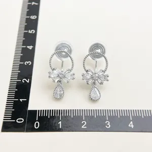 Detailed view of micro-set zircon bow clip earrings with drop pendant, elegant fashion jewelry.