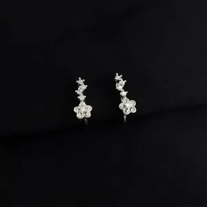 Closeup view of exquisite silver-tone flower clip earrings with sparkling cubic zirconia stones.