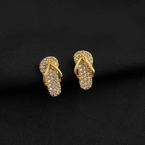 Nahaufnahme von vergoldeten Strass Flip Flop Ohrringen Detail, glitzernder Kristallschmuck.