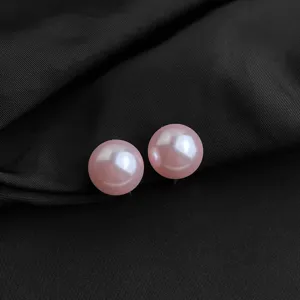Nahaufnahme Detail eleganter rosa Perlen Clip Ohrringe mit glänzender, glatter Oberfläche.