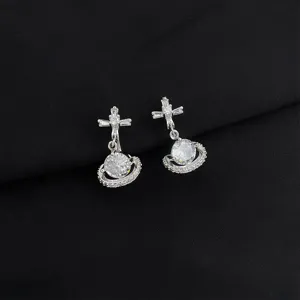 Detailed close-up of sparkling silver orb and cross earrings with brilliant cubic zirconia.