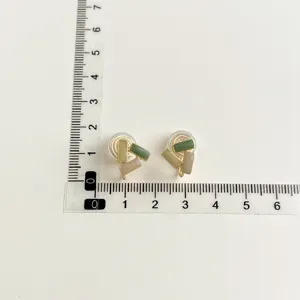 Detailed view of geometric clip-on earrings with colorful resin blocks and gold plating.