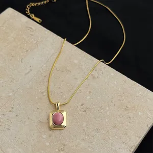 Close-up detail of 18k gold plated stainless steel necklace with pink natural stone pendant.