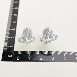 Exquisite silver heart-shaped saturn earrings with sparkling cubic zirconia, clip-on design.