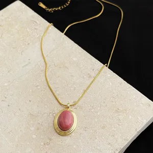 Detail shot of gold plated stainless steel pink stone pendant necklace for women stylish jewelry.