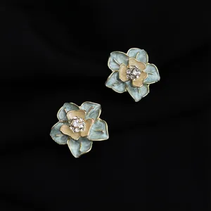 Eleganti orecchini clip a fiore in smalto con strass brillanti e raffinato bordo dorato.