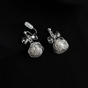 Elegant silver clip-on earrings featuring a bow crystal accent and wire-wrapped pearl ball.
