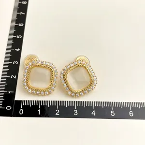Elegante vergoldete quadratische Ohrclips mit weißen Steinen und glänzendem Zirkonia.
