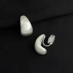 Matte silver teardrop clip-on earrings close-up, comfortable silicone cushion, detail view.